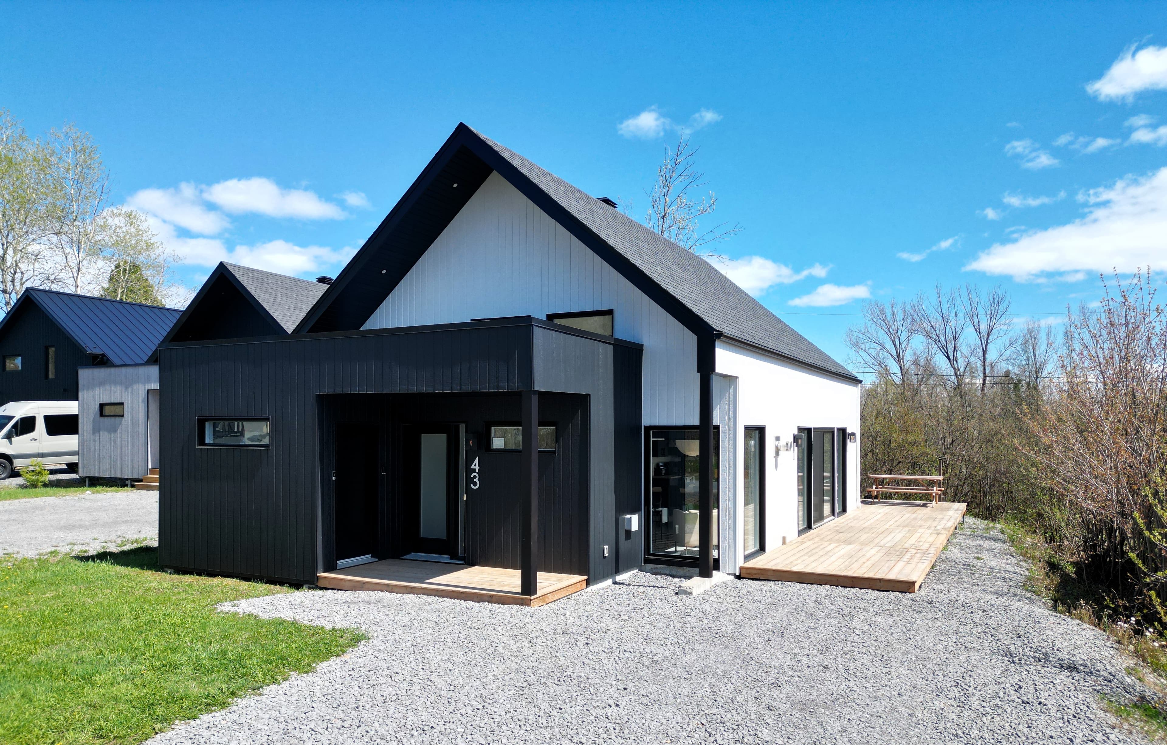 Chalet moderne au Mont-Sainte-Anne, terrasse de bois et grandes fenêtres