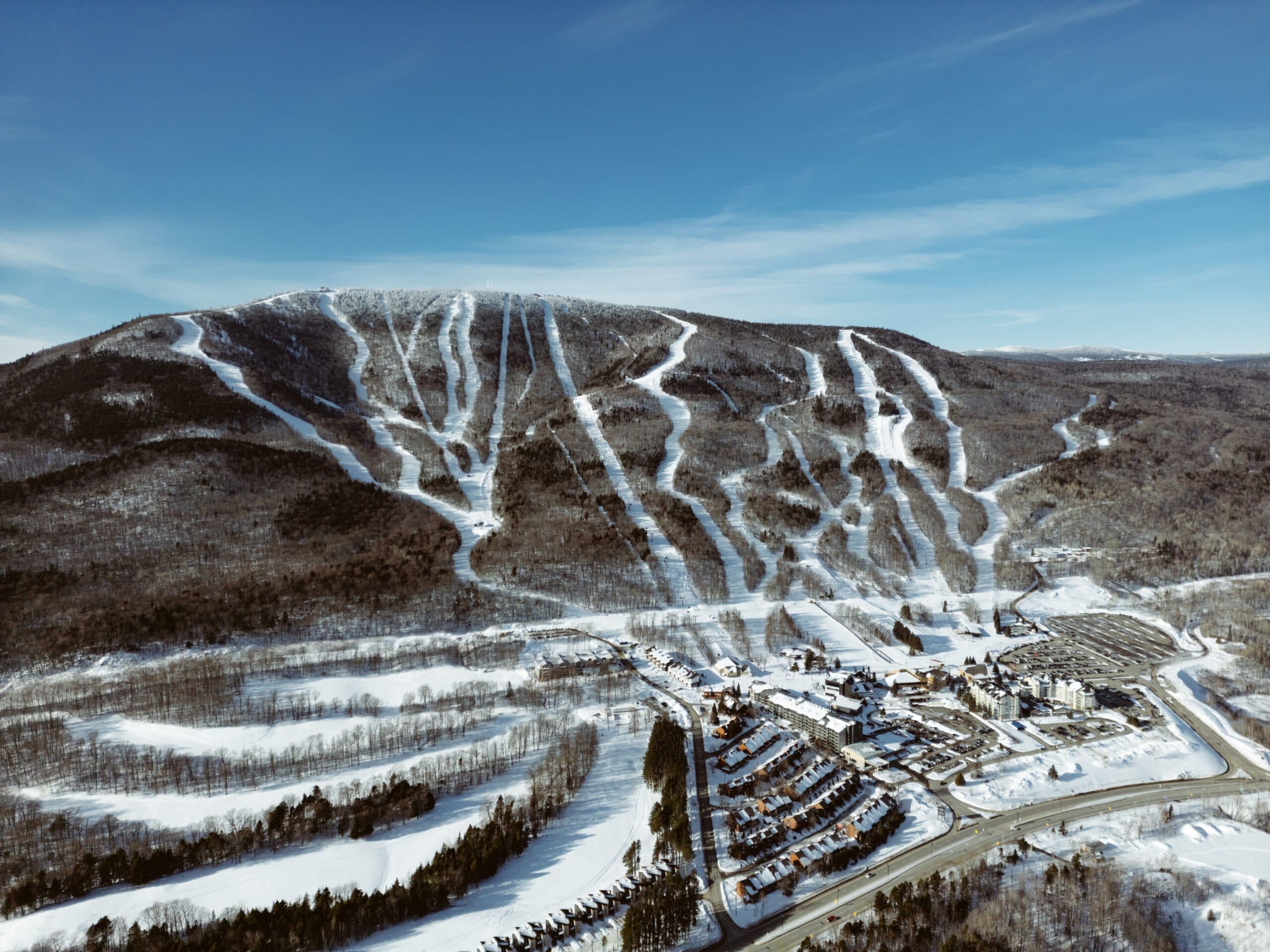 Vue aérienne du Mont-Sainte-Anne en hiver : pistes, station et stationnement