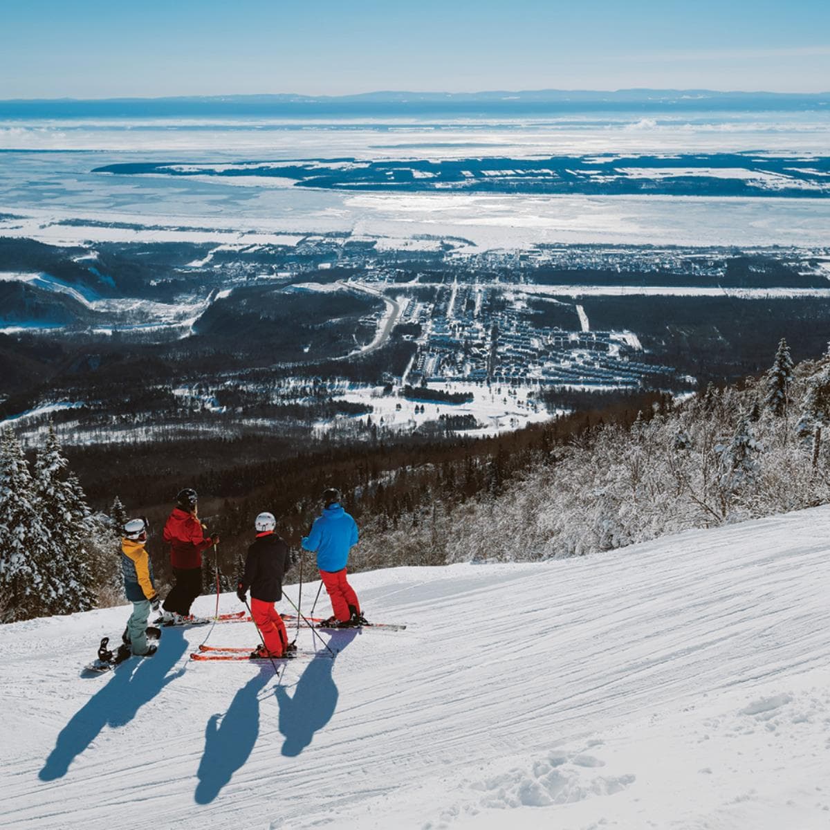Skieurs au sommet du Mont-Sainte-Anne, vue sur la vallée et le fleuve Saint-Laurent